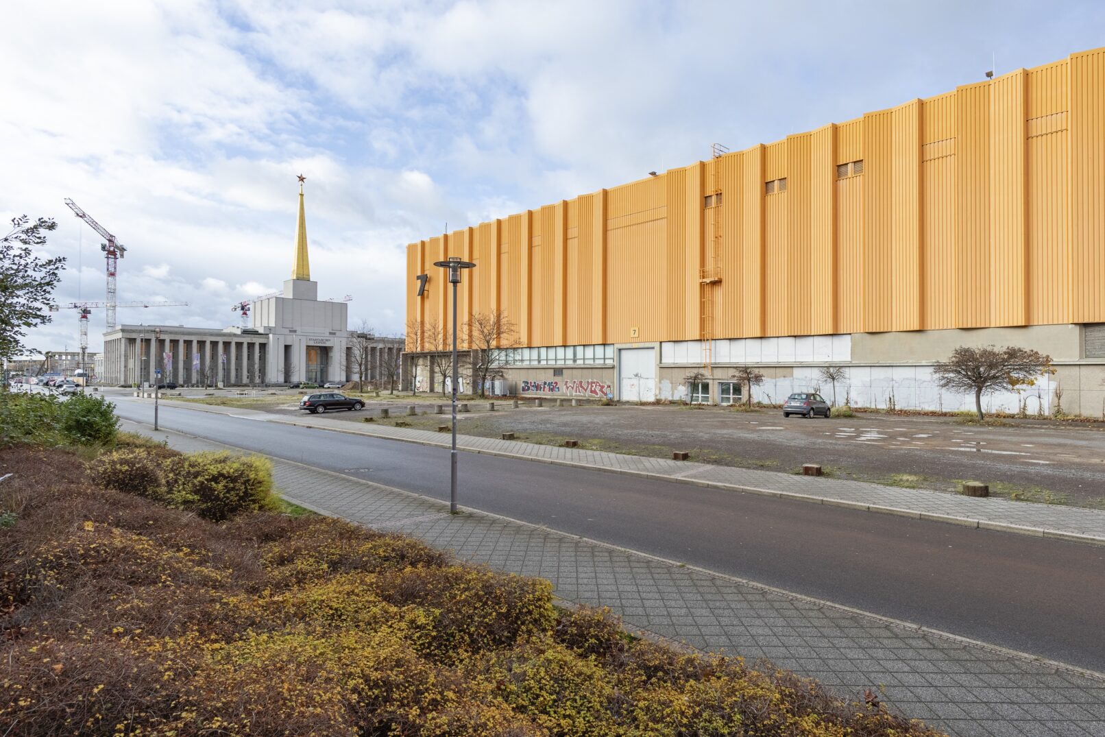 gelbes Gebäude an einer Straße mit Parkplatz davor