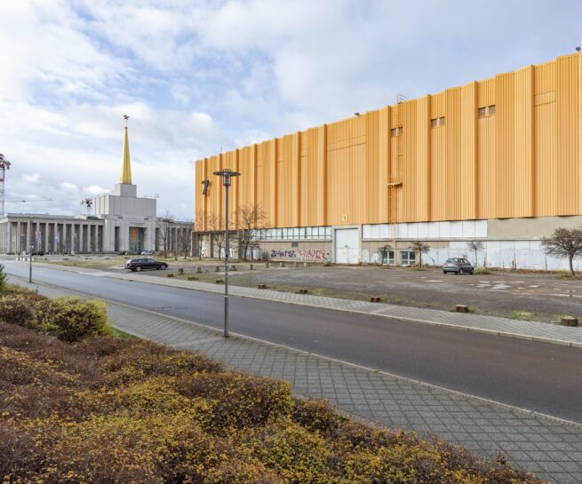 gelbes Gebäude an einer Straße mit Parkplatz davor